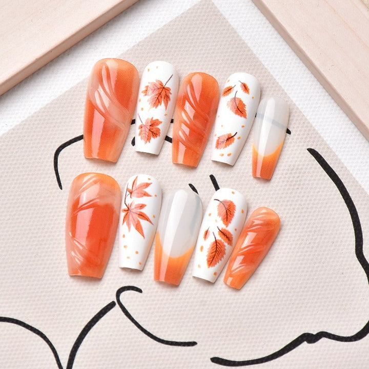 Kunstnagelset mit eleganten Herbstmotiven und glänzenden Akzenten Karnz