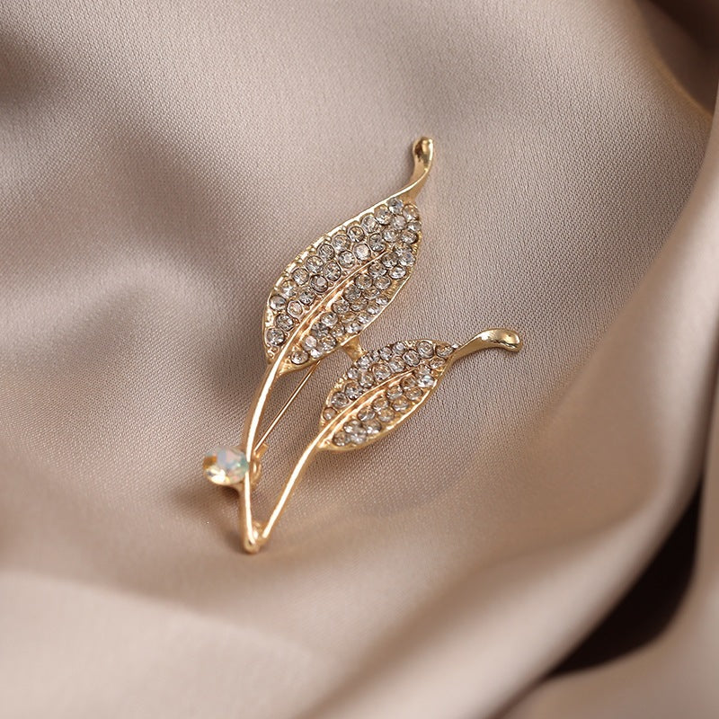 Elegante Brosche mit Blattform und Kristallen Karnz