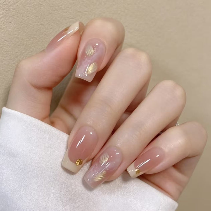 Elegante französische Nagelverlängerungen mit goldenen Akzenten