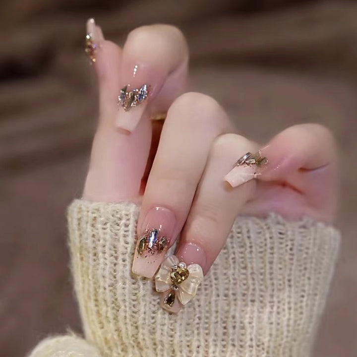Kunstvolle Nagelkunst mit Schmetterlings- und Perlendetails Karnz