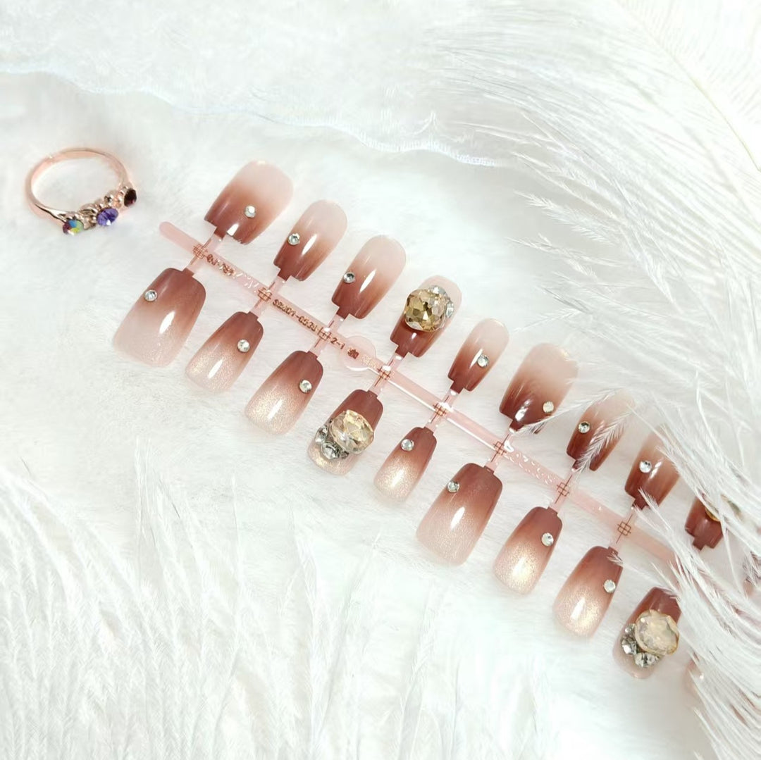 Kunstnägel im eleganten Ombre-Stil mit strassverzierten Applikationen Karnz