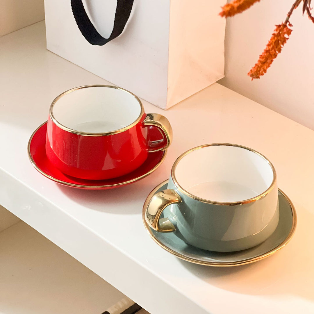 Elegante Porzellan-Tasse mit Untertasse und skulpturellem Goldhenkel