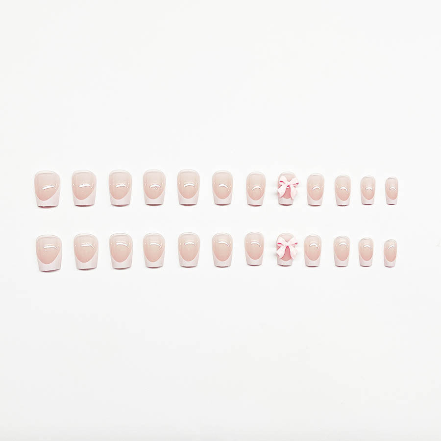 Dekorative French Tip Nagelverlängerungen mit Schleifenakzenten Karnz