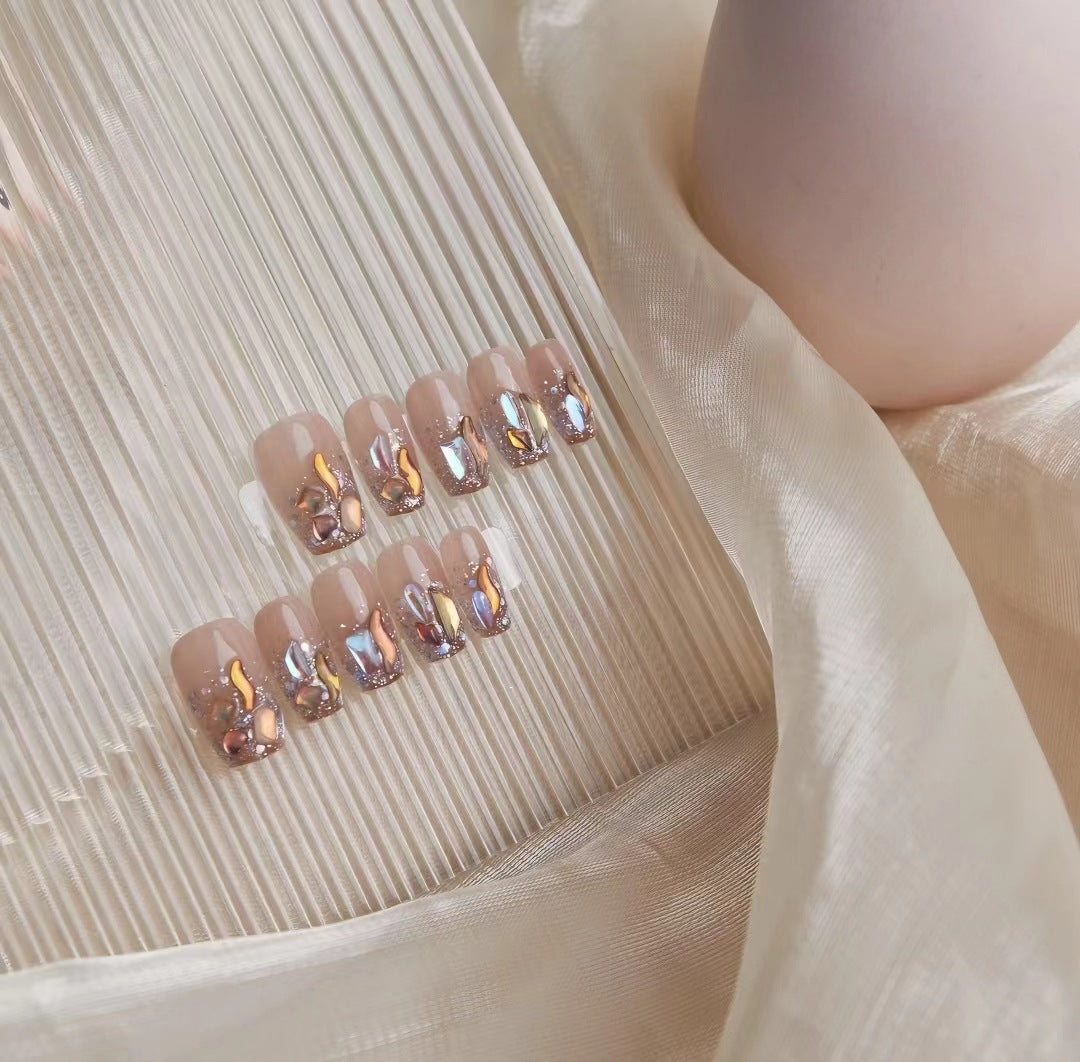 Kunstvolle Nagelkunst mit Schmetterlings- und Perlendetails Karnz