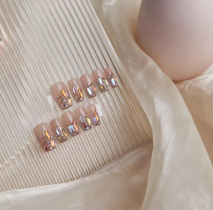 Kunstvolle Nagelkunst mit Schmetterlings- und Perlendetails Karnz