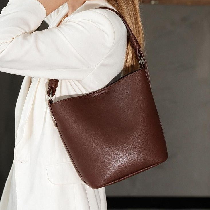 Strukturierte Leder-Schulter-Bucket-Tasche mit geknotetem Träger