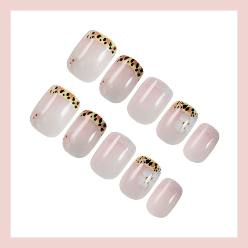 Kunstnagelset mit eleganter französischer Spitze und floralem Akzent Karnz