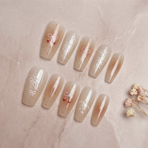 Dekorativer Press-On-Nagelset mit eleganten Schleifenmustern