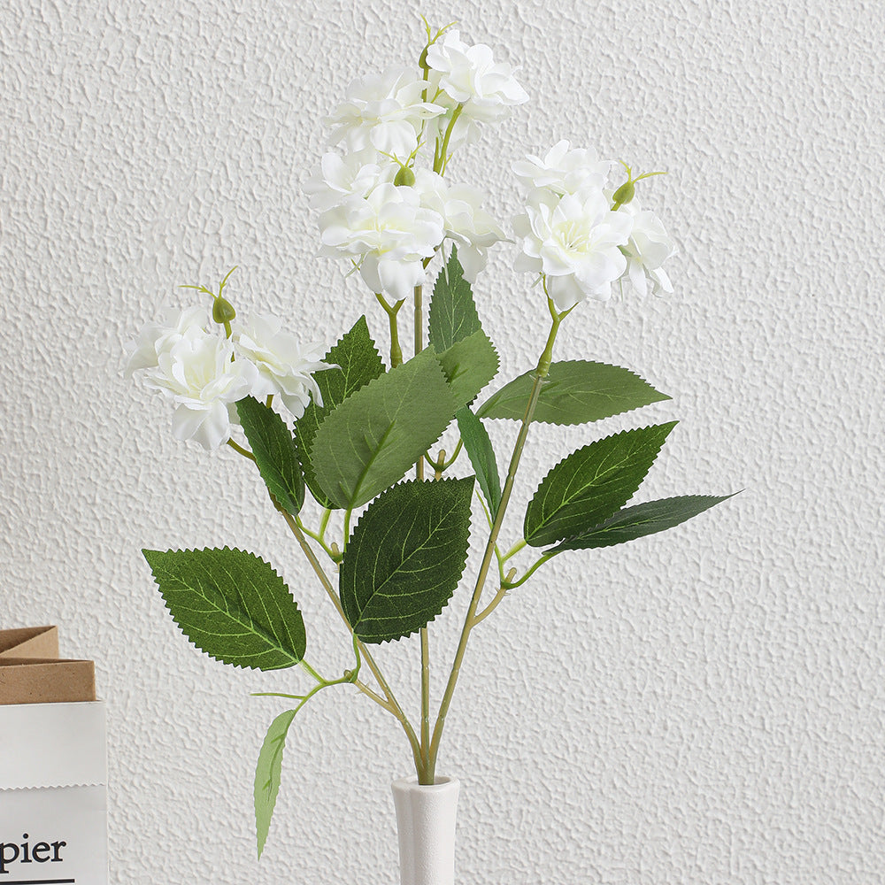 Kunstblumenarrangement mit zarten weißen Blüten Karnz