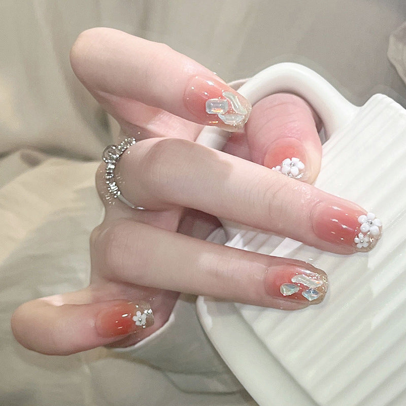 Dekoratives Kunstnagelset mit eleganten Blumen- und Glitzerelementen Karnz