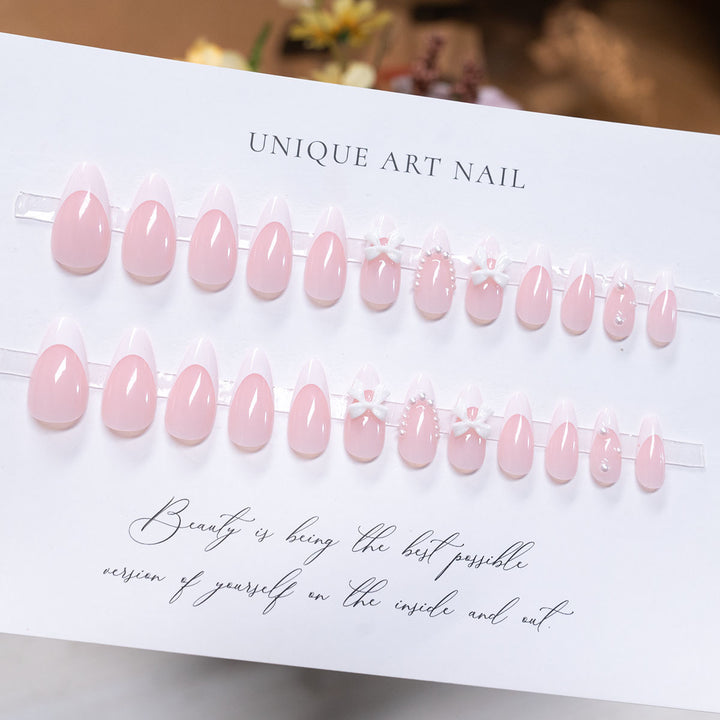 Dekorative Press-On-Nagelkunst mit Schleifenakzenten