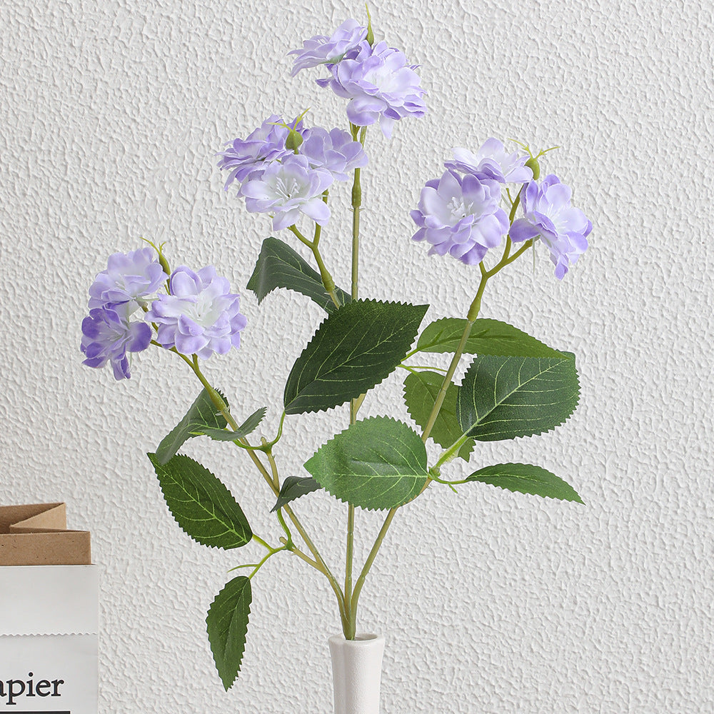 Kunstblumenarrangement mit zarten weißen Blüten Karnz