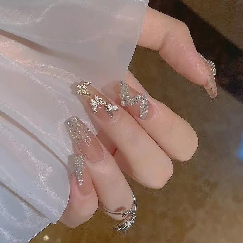 Glamouröse Nagelkunst mit Strass- und Schmetterlingselementen Karnz