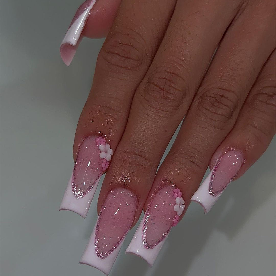 Kunstvolle Nagelverlängerungen mit Glitzer- und Blumenakzenten Karnz