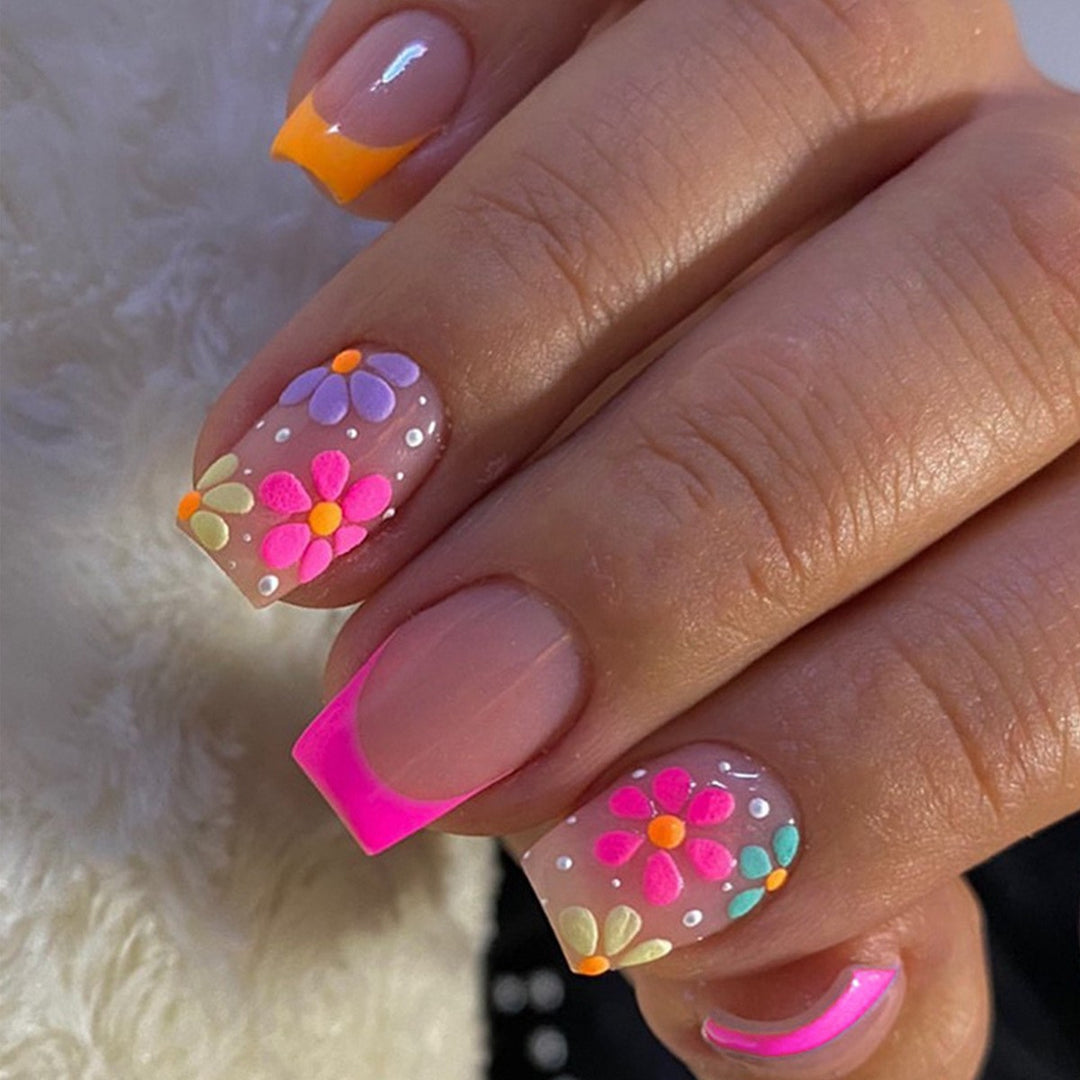 Kunstnagelset mit bunten Blüten und kreativem French-Design Karnz