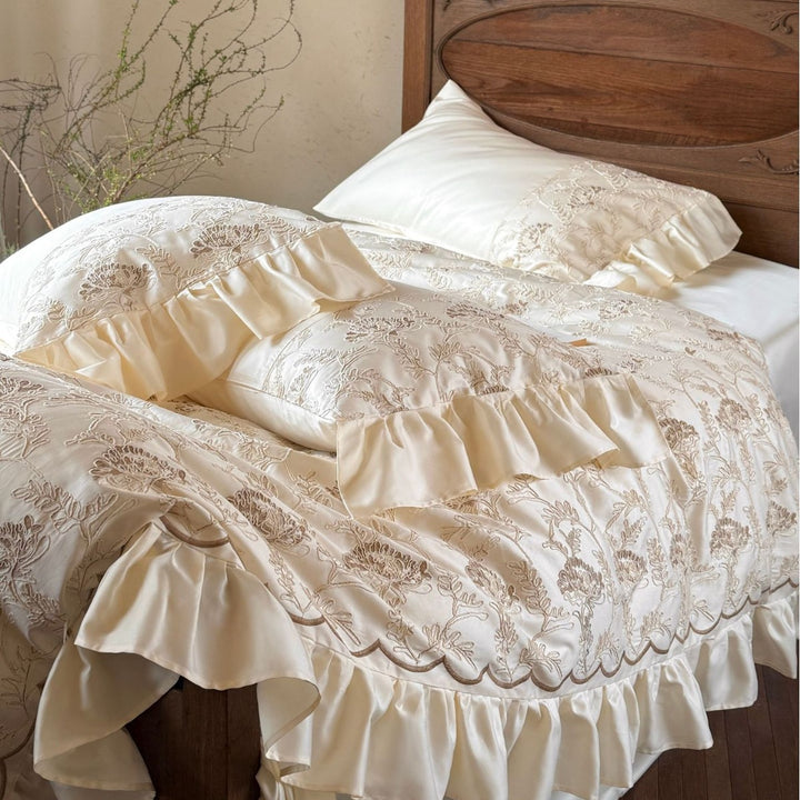 Steppbett mit floraler Stickerei, Satinvolant und dekorativer Biese