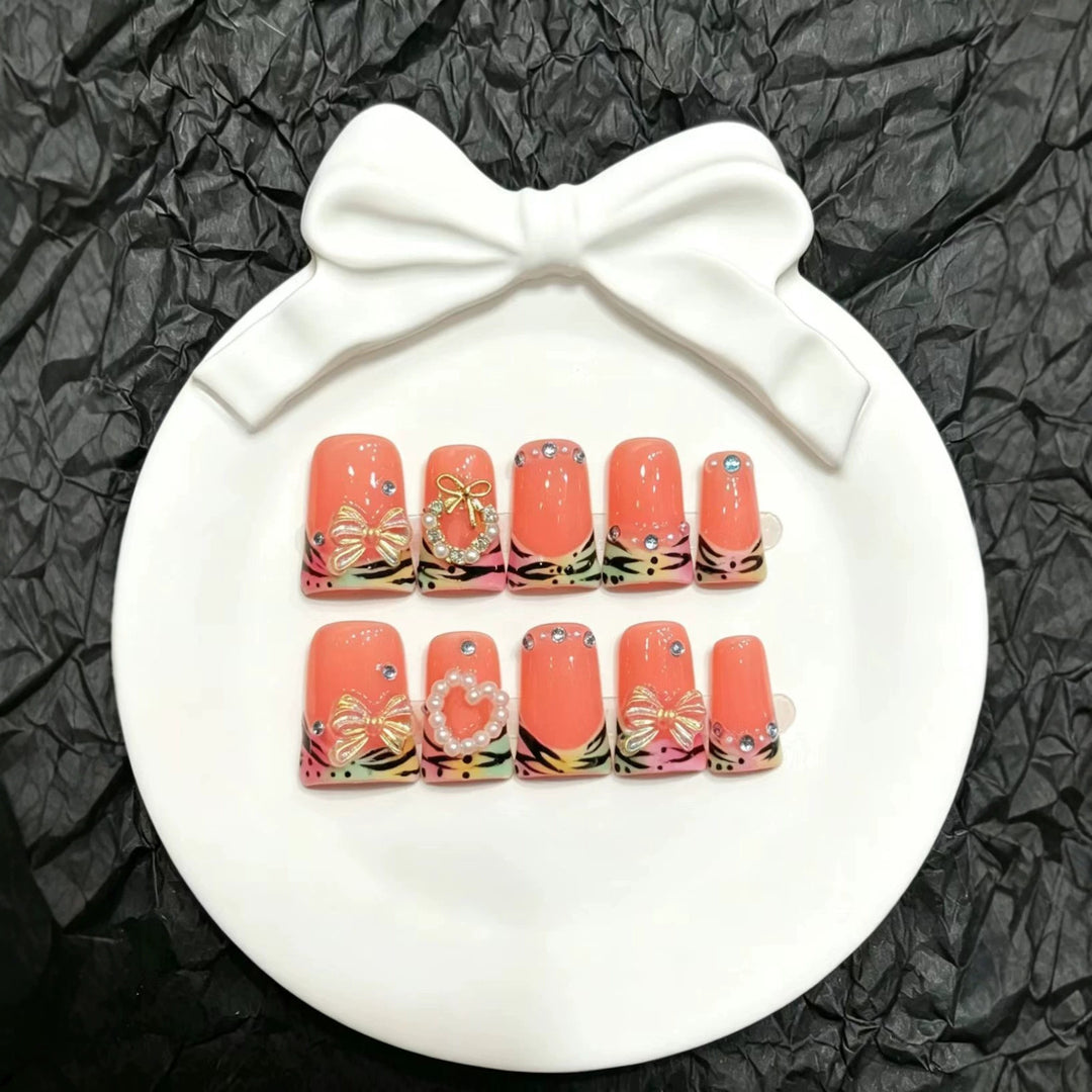 Dekoratives Press-On Nagelset mit eleganten Blumen- und Schleifenakzenten