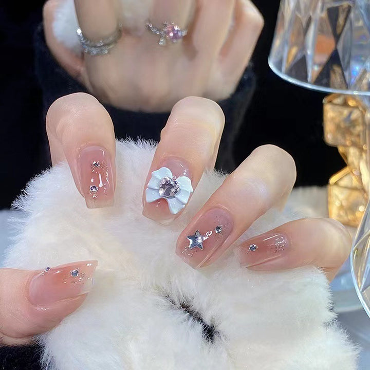Kunstvolle Nagelspitzen mit floralen und glitzernden Akzenten Karnz