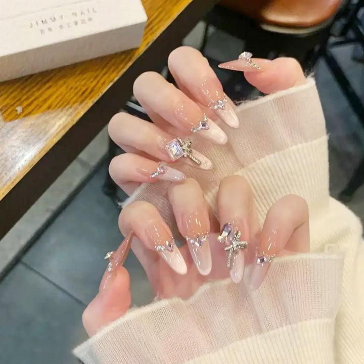 Kunstnagelset mit eleganten Kristallverzierungen und Ombre-Effekt Karnz