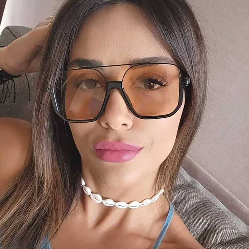 Damen quadratische Sonnenbrille mit transparentem Rahmen und grün getönten Gläsern Karnz