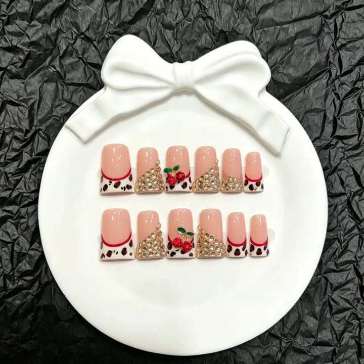 Dekorativer Press-On Nagelkunst-Set mit glamourösen Strasssteinen und Kirschakzenten