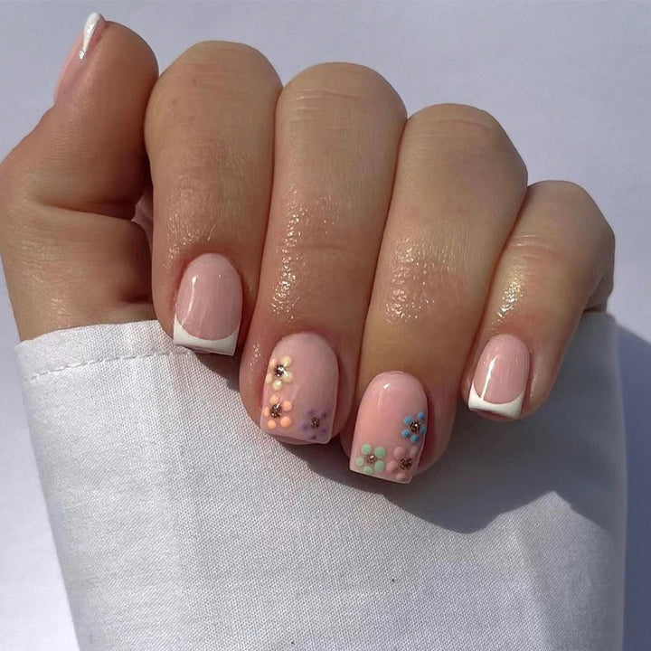 Kunstvolle Nagelkunst mit floralem Akzent und elegantem French-Tip Karnz