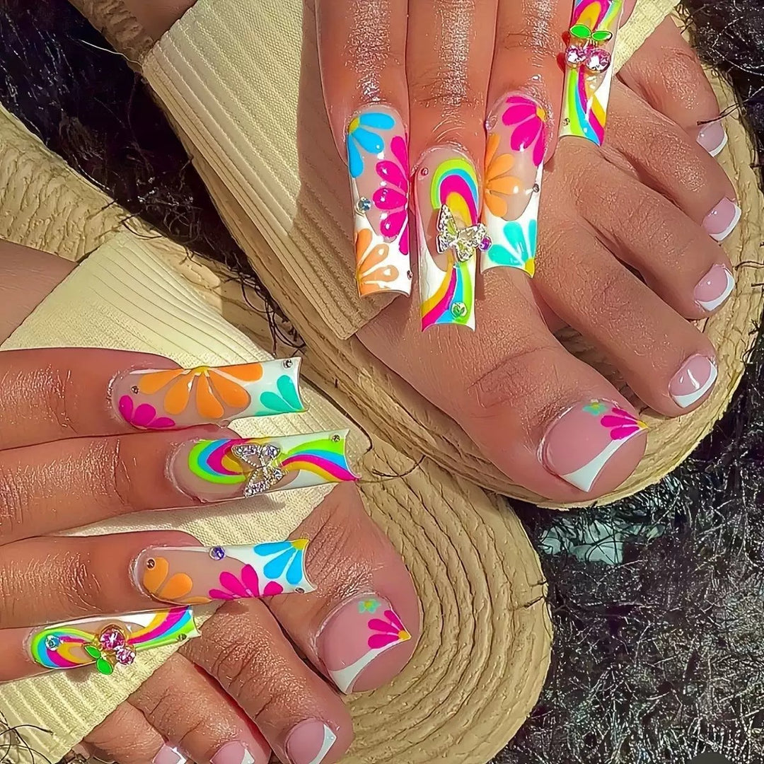 Kunstnagelset mit leuchtenden Blumenmotiven und Glitzerakzenten Karnz