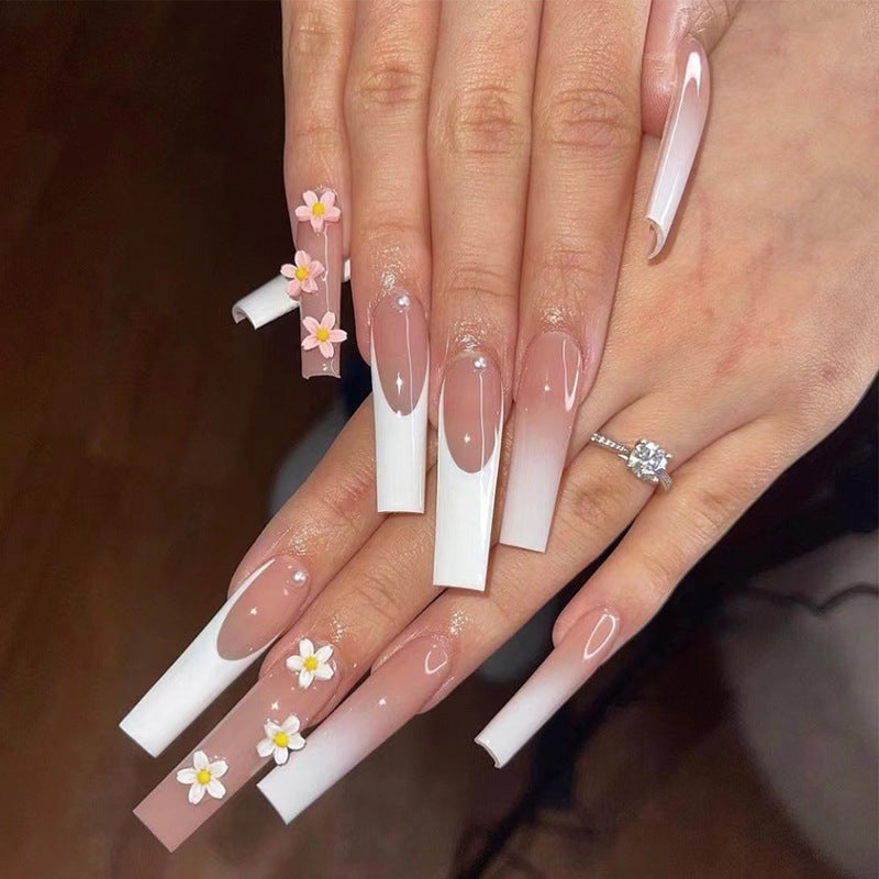 Kunstvolle Nagelverlängerungen mit elegantem Farbverlauf und kreativen Blumenakzenten Karnz