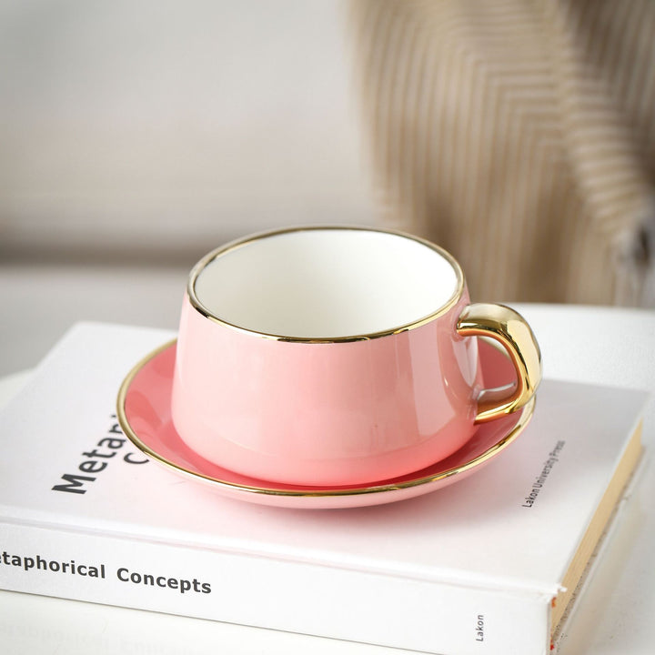 Elegante Porzellan-Tasse mit Untertasse und skulpturellem Goldhenkel