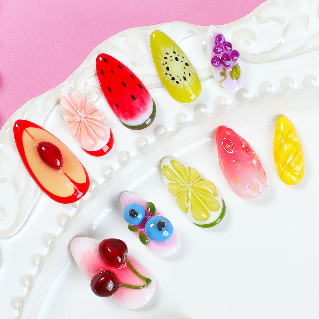 Kreatives Kunstnagelset mit bunten Obstdesigns Karnz