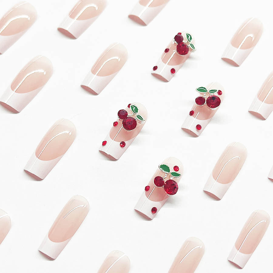 Kunstnagelset mit chicen Kirschmotiven und eleganter French-Spitze Karnz