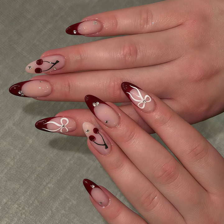 Künstlerisches Stiletto Press-On Nagelset mit Kirsch- und Schleifenmotiven Karnz