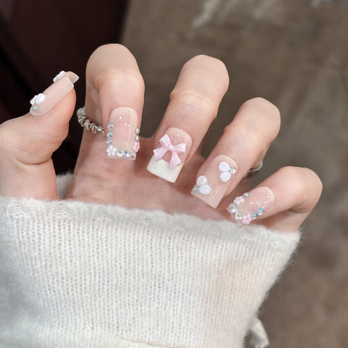 Dekoratives Nagelkunstset mit floralen Details und Schleifenakzenten