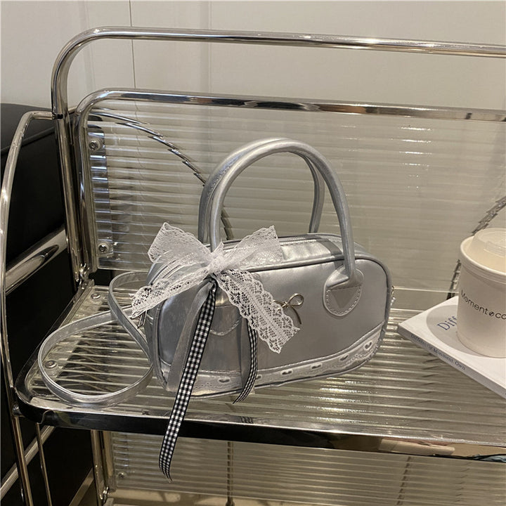 Elegante mit Spitzenbesatz verzierte Bogenhandtasche Karnz