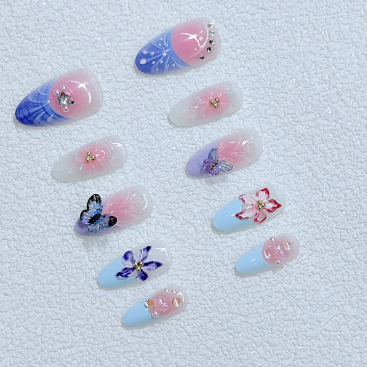 Kunstvolle Nagelkunst mit Blumendetails und Schmetterlingen Karnz