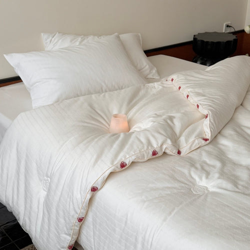 Steppbett aus Baumwollsatin mit gestickter Rosenborte