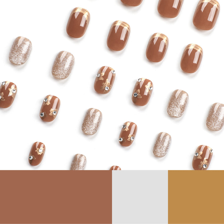 Elegante Nageldekoration mit Glitzer und floralen Akzenten Karnz