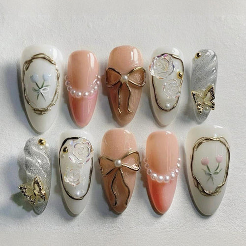 Kunstnagelset mit romantischen Blüten- und Goldverzierungen Karnz