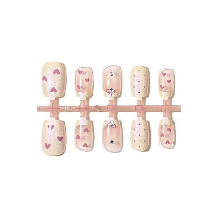 Dekorativer Press-On-Nagelset mit Herz- und Bogenmotiven