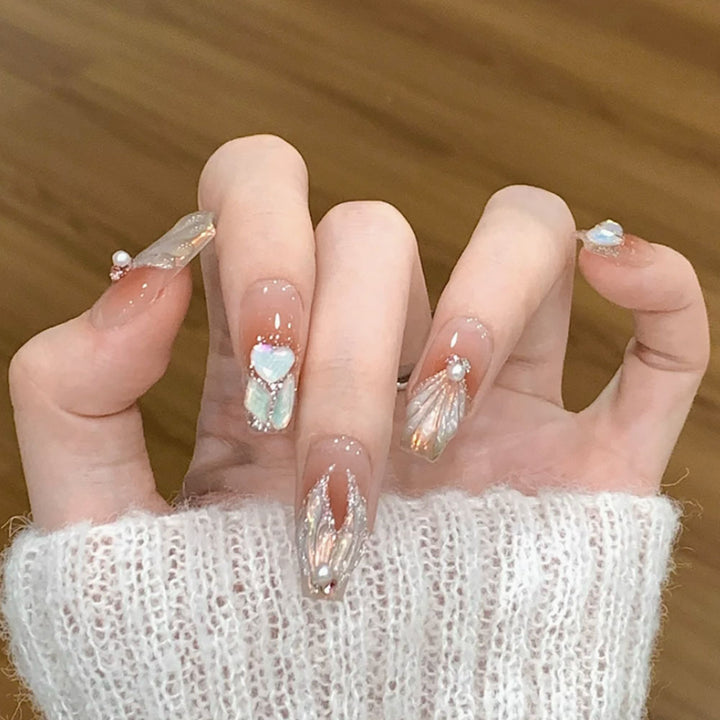 Dekorative Press-On-Nagelkunst mit Perlenakzenten und Muschel-Design