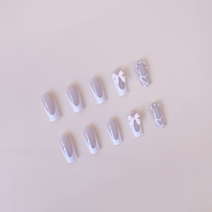 Kunstnagelset mit eleganten Schleifen- und Glitzerverzierungen Karnz
