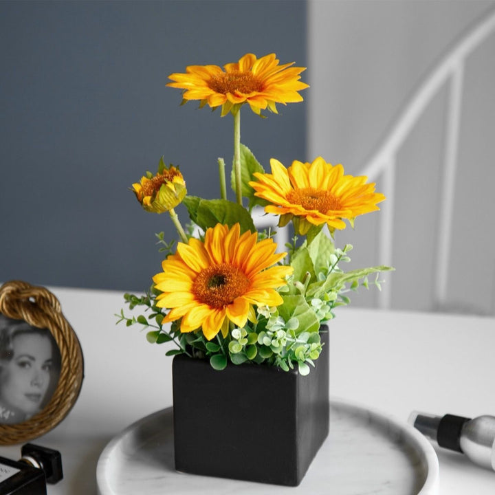 Lebensechte Blumenarrangement in dekorativem quadratischen Pflanzgefäß