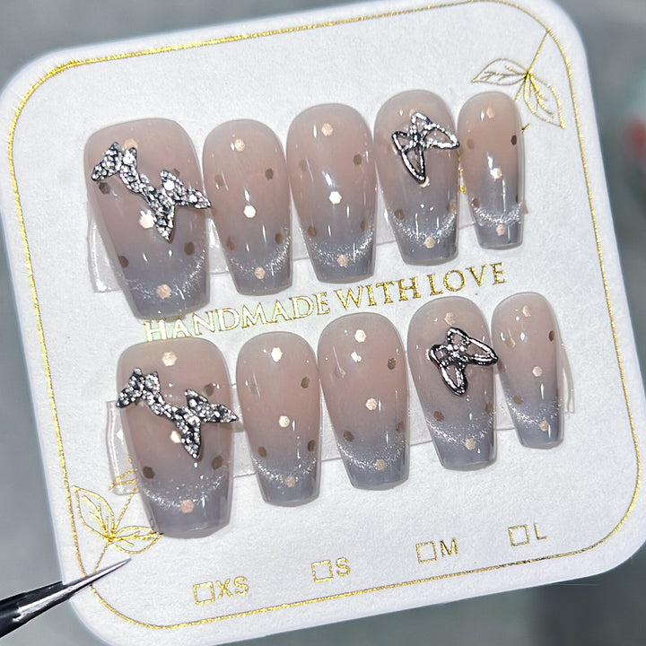 Künstliche Nagelkunst mit Glitzer-Details und Schleifenakzenten Karnz