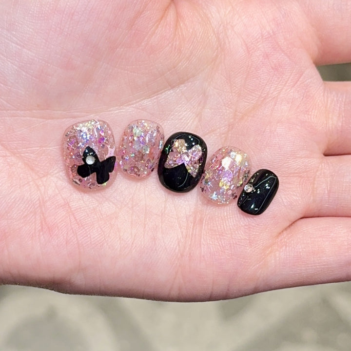 Kunstnägel mit Glitter- und Schleifenakzenten Karnz