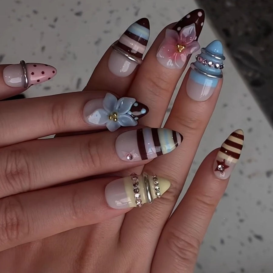 Kreatives Kunstnagelset mit floralen und gestreiften Akzenten Karnz