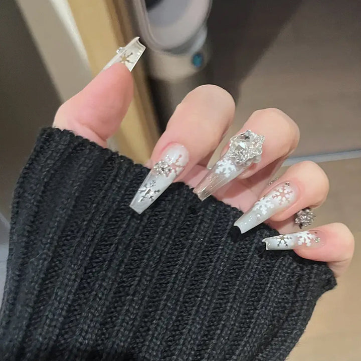Kunstnagelset mit frostigem Schneeflocken-Design und funkelnden 3D-Applikationen Karnz
