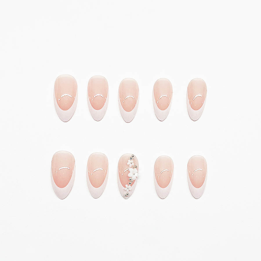 Kunstnagelset mit filigranen Blütenverzierungen und elegantem French Design Karnz