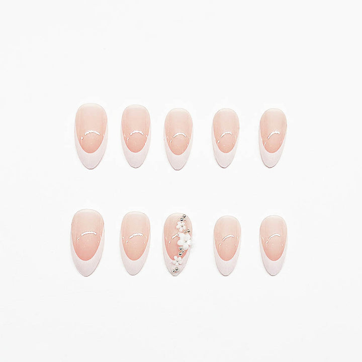 Kunstnagelset mit filigranen Blütenverzierungen und elegantem French Design Karnz