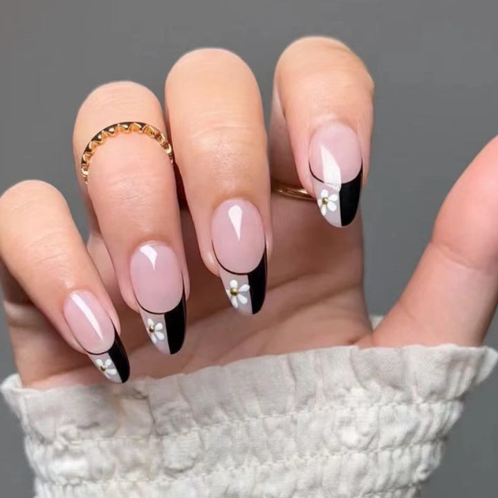 Kunstvolle Nagelkunst mit eleganten Schwarz-Weiß-Design und floralen Akzenten Karnz
