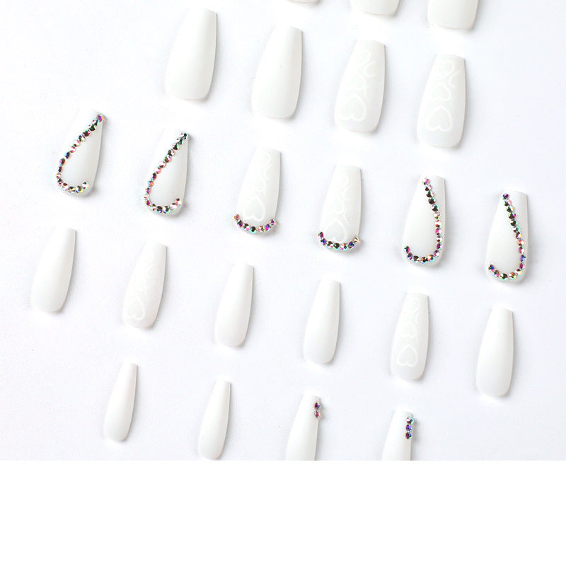 Kunstvolle Nagelverlängerungen mit Herzen-Design und Glitzerakzenten Karnz
